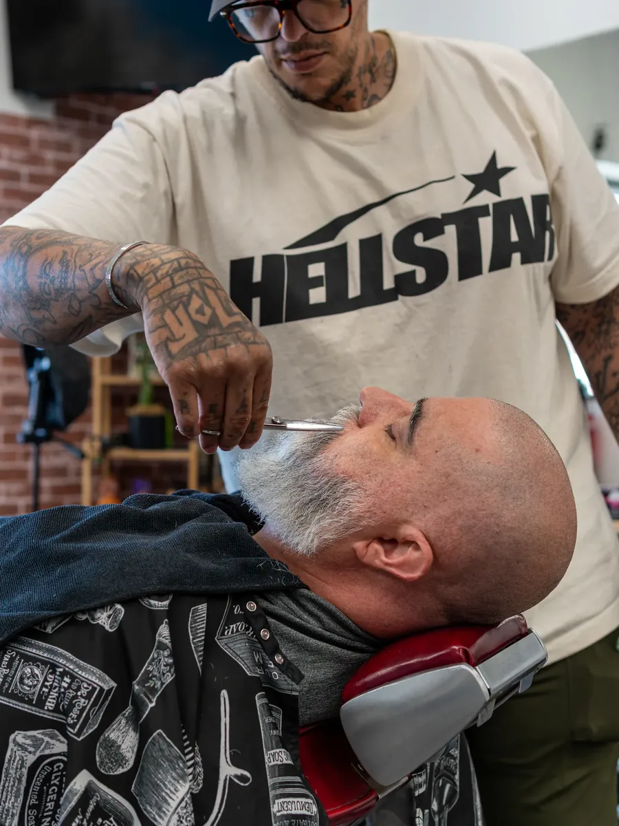 A barber trims a customer’s hair at Giovanni’s Barbershop.