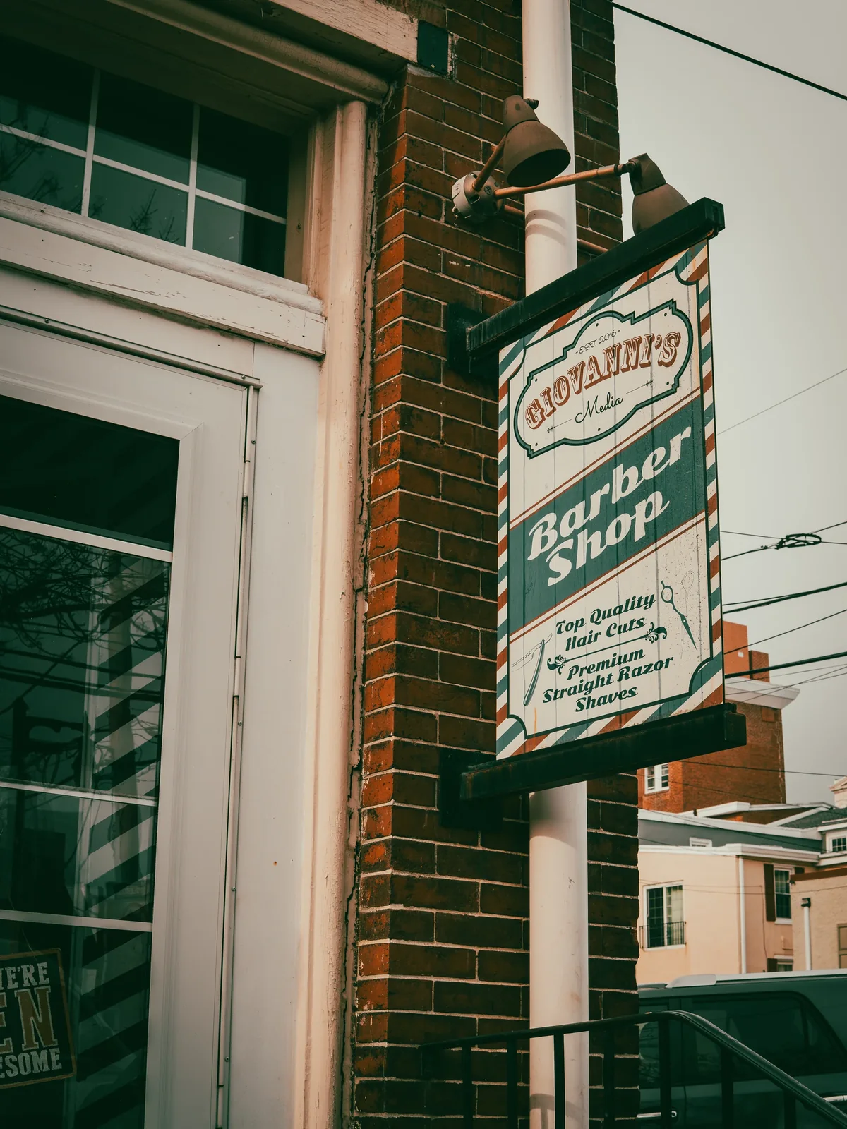 Giovanni’s Barbershop sign mounted outside a brick storefront.