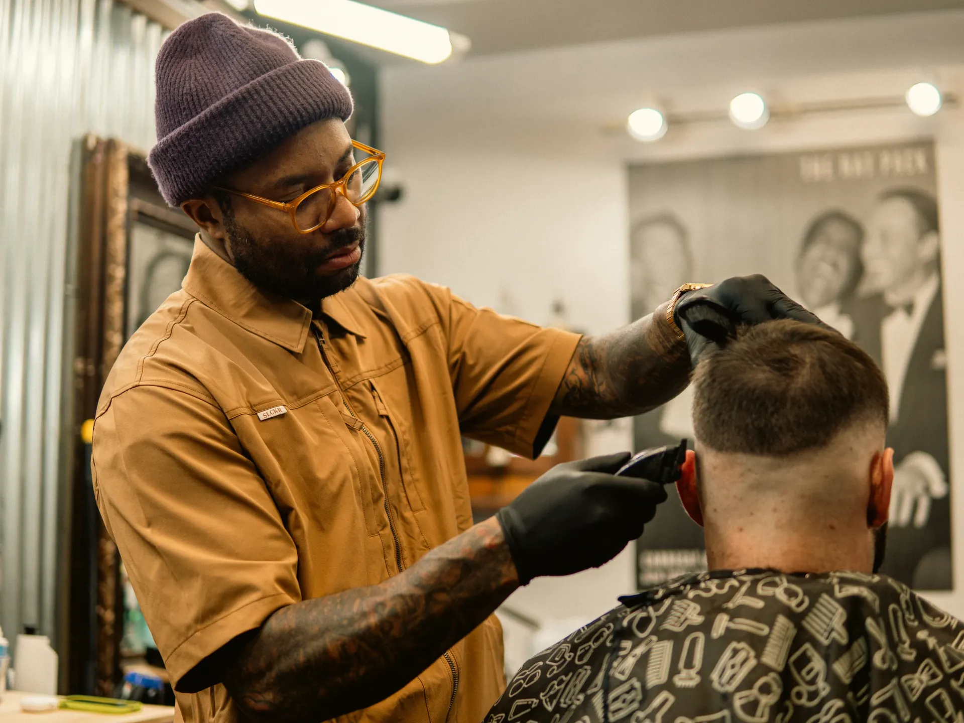 A barber carefully cutting a customer's hair in a neighborhood barbershop