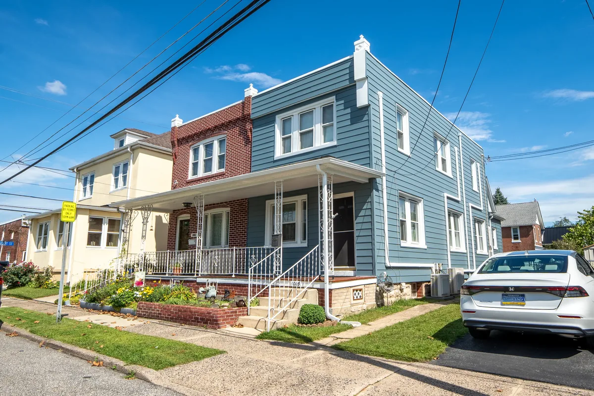 A renovated rowhome exterior with blue-gray siding and white trim.