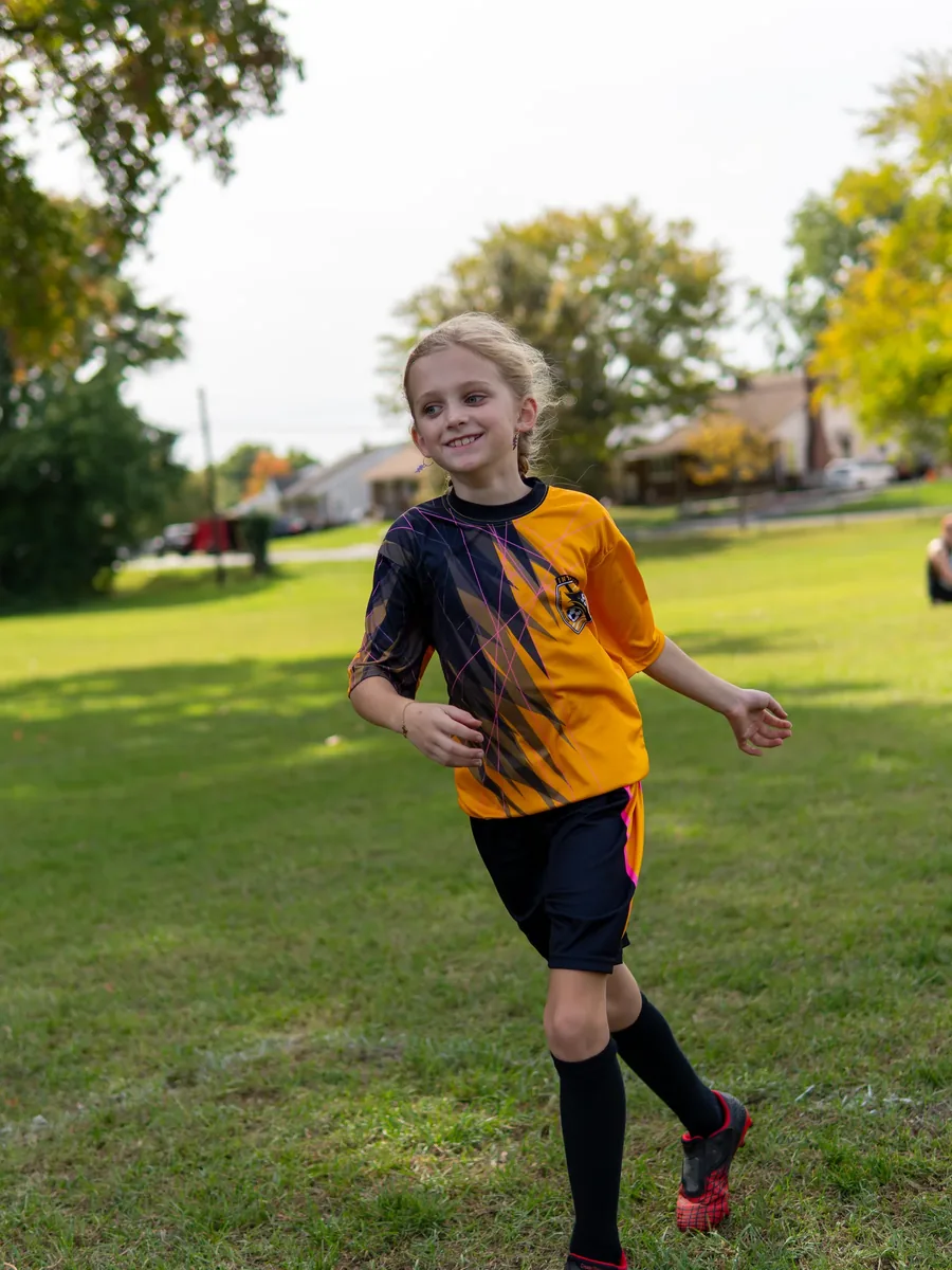 A soccer player runs across the field during practice.