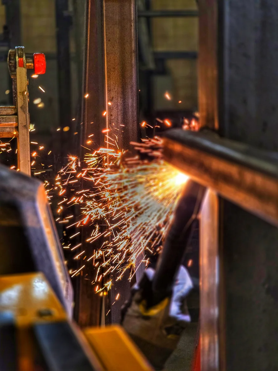 A burst of sparks crosses steelwork during workshop fabrication.